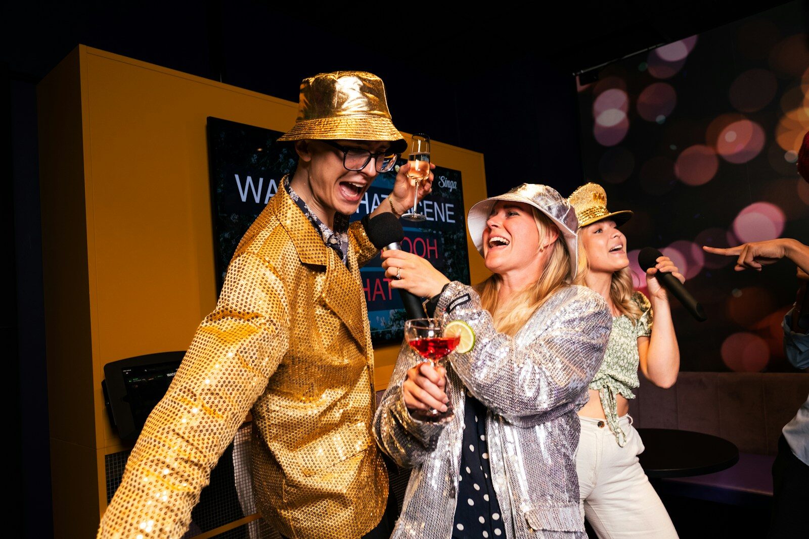 People are partying and singing karaoke with microphones.